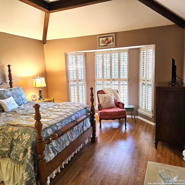 bedroom featuring multiple windows, lofted ceiling with beams, and wood-type flooring