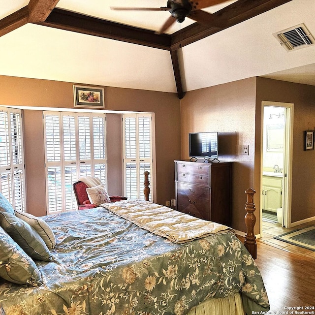 bedroom featuring ensuite bath, ceiling fan, hardwood / wood-style floors, and lofted ceiling with beams