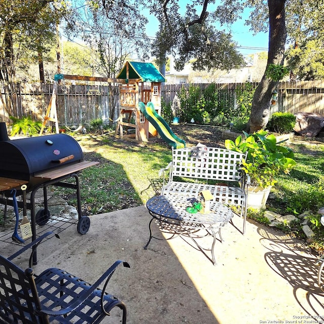 view of patio with a playground and grilling area