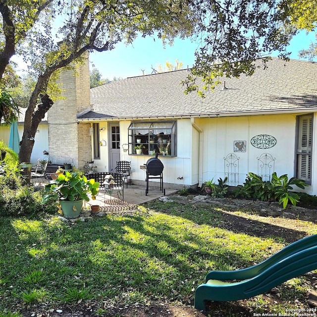 rear view of house featuring a patio area and a yard