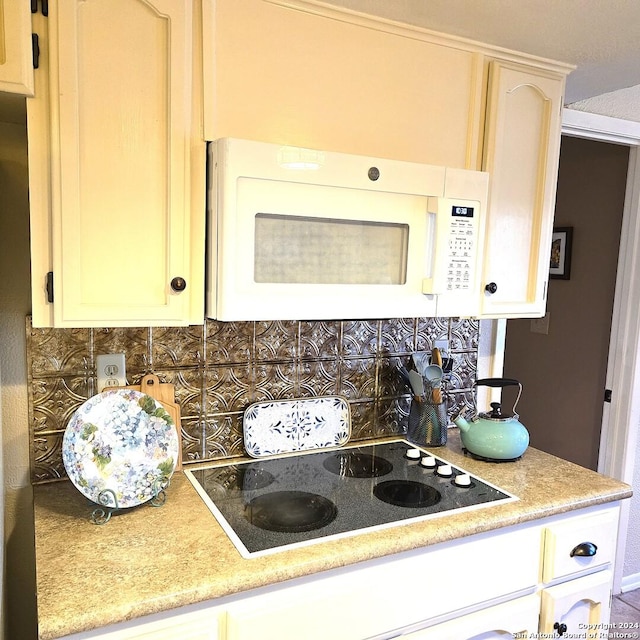 kitchen with tasteful backsplash and electric stovetop