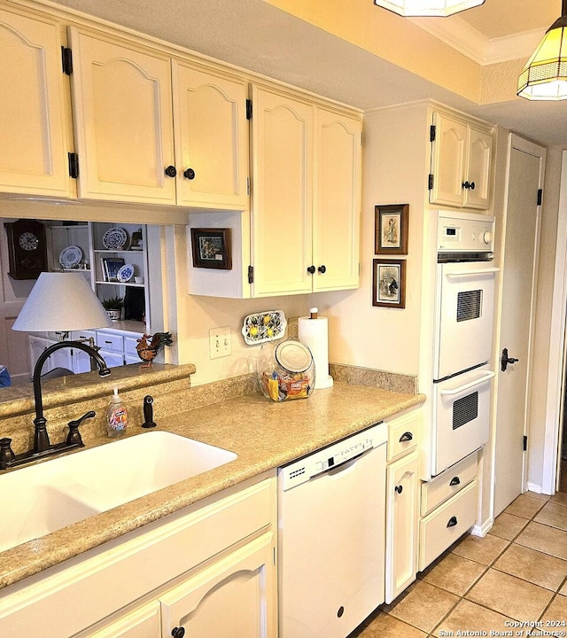 kitchen featuring light tile patterned flooring, white appliances, and sink