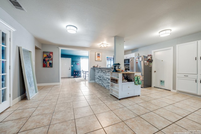 kitchen featuring white cabinets, light tile patterned floors, and appliances with stainless steel finishes