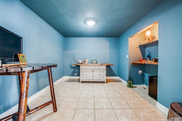 office featuring light tile patterned flooring and built in desk