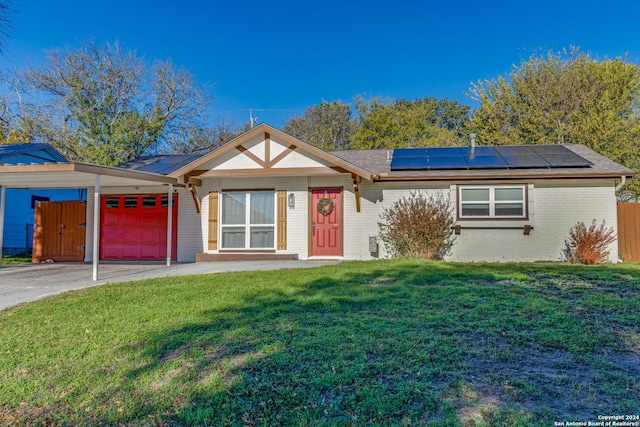 single story home with a front yard, solar panels, and a garage