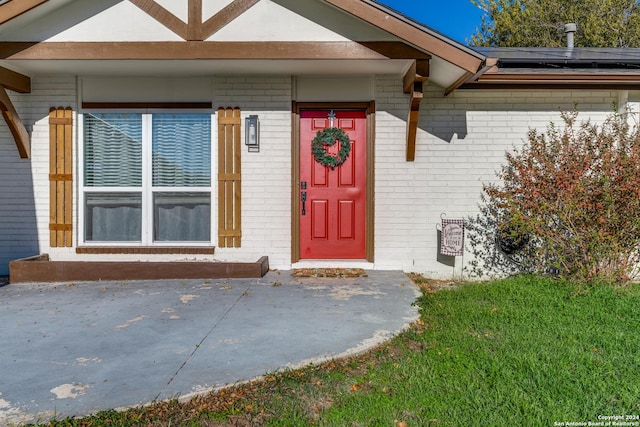 4023 Goshen Pass, San Antonio, TX 78230 - view of exterior entry with brick siding, roof mounted solar panels, and a yard