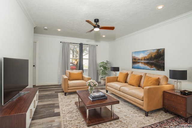 living room with a textured ceiling, hardwood / wood-style flooring, ceiling fan, and ornamental molding