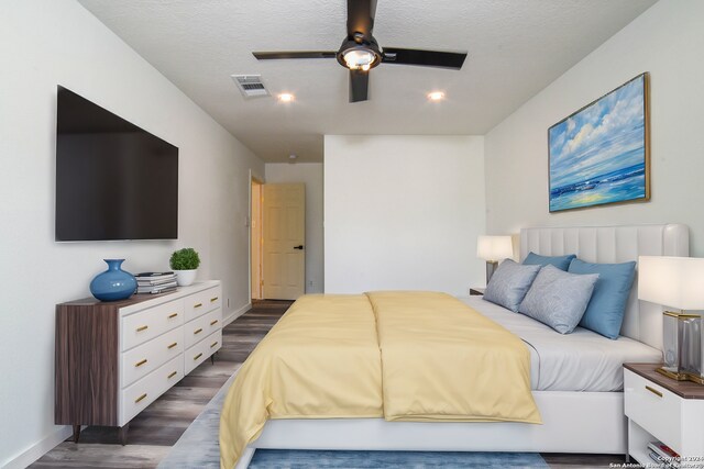 bedroom featuring a textured ceiling, ceiling fan, and dark wood-type flooring