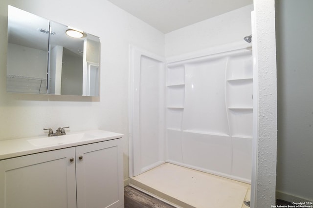 bathroom featuring a shower, hardwood / wood-style floors, and vanity