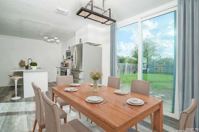 dining space featuring wood-type flooring and a textured ceiling