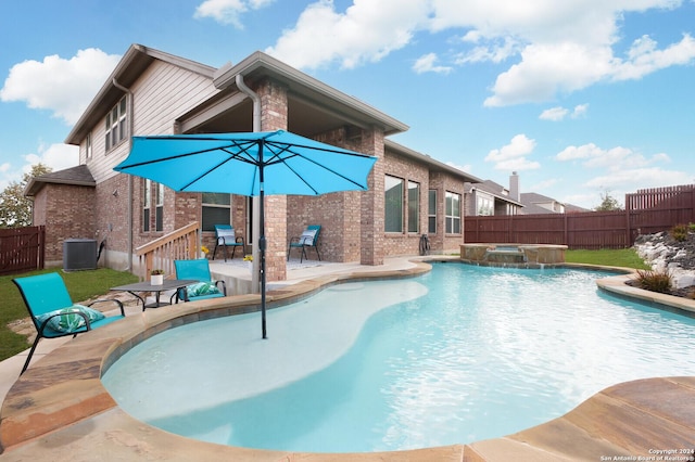 view of pool featuring an in ground hot tub, pool water feature, a patio area, and central air condition unit