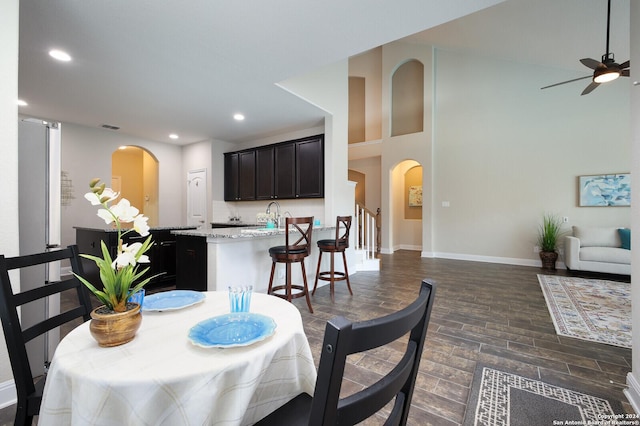 dining room featuring ceiling fan, sink, and dark wood-type flooring