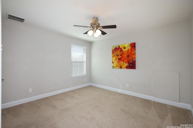 carpeted spare room with ceiling fan