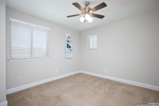 carpeted spare room featuring ceiling fan