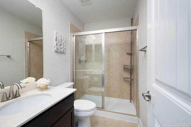 bathroom with walk in shower, tile patterned floors, a textured ceiling, toilet, and vanity