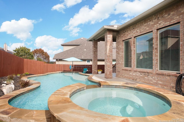 view of swimming pool with an in ground hot tub