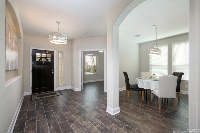 foyer entrance featuring dark wood-type flooring and a notable chandelier