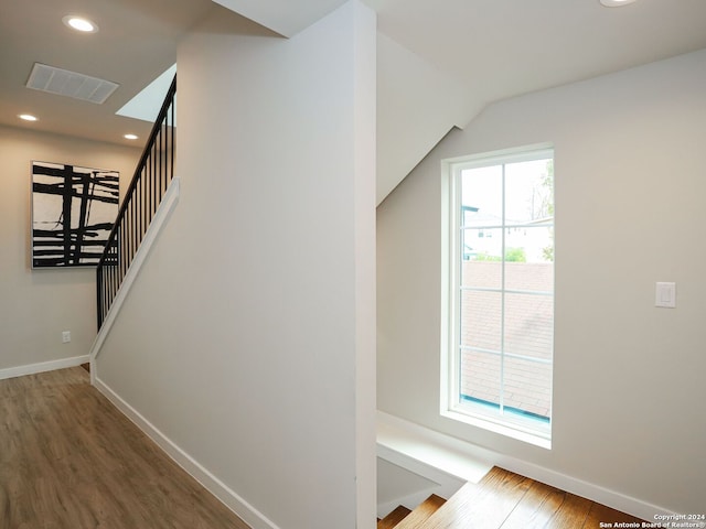 staircase featuring hardwood / wood-style flooring and vaulted ceiling