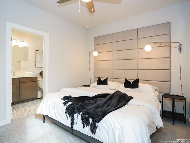 bedroom with light colored carpet, ensuite bath, and ceiling fan