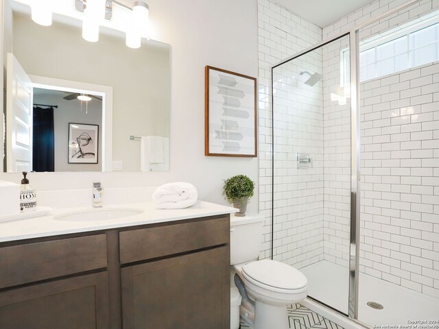 bathroom featuring vanity, toilet, and a shower with door