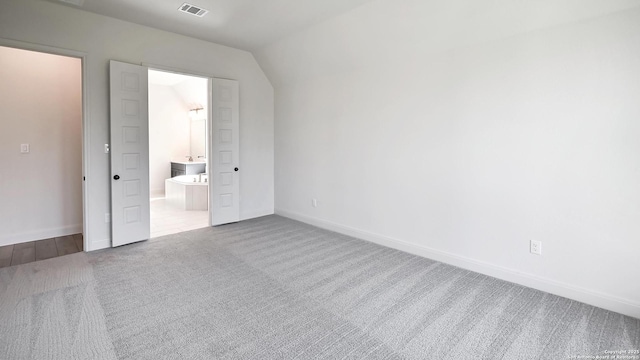unfurnished bedroom featuring carpet floors, baseboards, connected bathroom, and visible vents