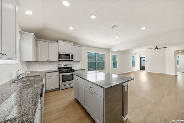 kitchen with a center island, stainless steel appliances, plenty of natural light, and sink