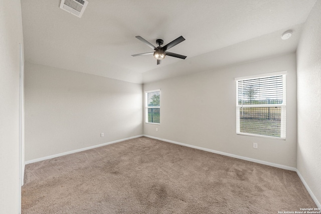 empty room featuring ceiling fan and light carpet