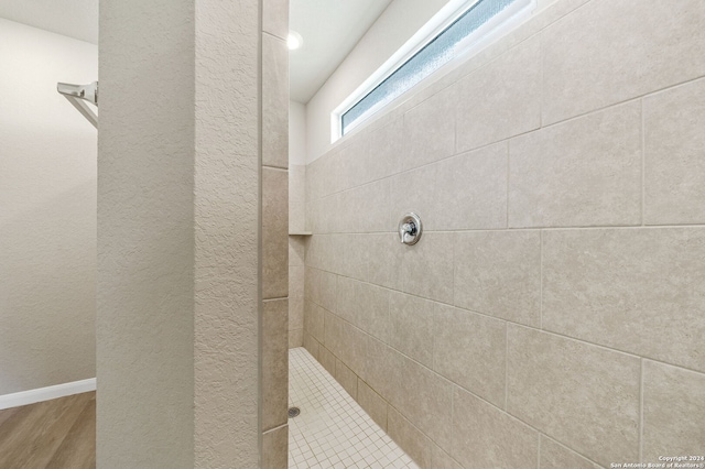 bathroom featuring a tile shower and hardwood / wood-style floors