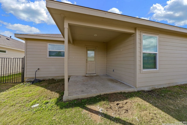 doorway to property featuring a lawn and a patio area