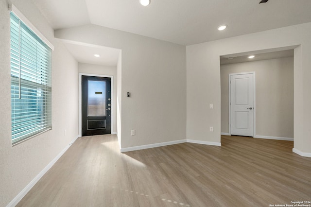 unfurnished room featuring light hardwood / wood-style floors and lofted ceiling