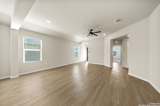 unfurnished room with hardwood / wood-style floors, plenty of natural light, and ceiling fan