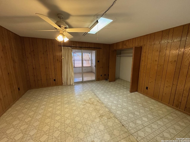 interior space featuring wooden walls and ceiling fan