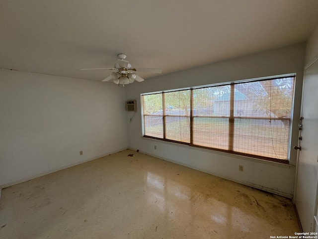 spare room featuring a wall mounted AC and ceiling fan