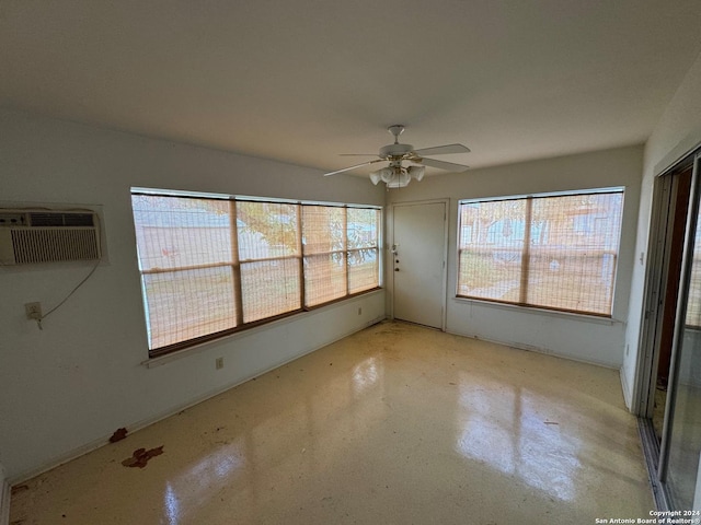 interior space with a wall mounted air conditioner and ceiling fan