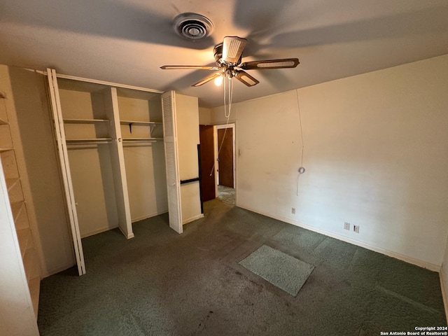 unfurnished bedroom featuring ceiling fan, dark carpet, and a closet