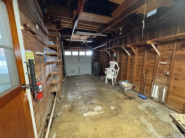 garage with wooden walls and a garage door opener