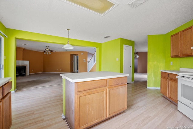 kitchen with a center island, hanging light fixtures, light hardwood / wood-style flooring, ceiling fan, and white range with electric stovetop