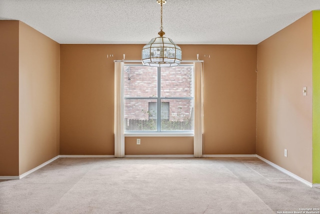 unfurnished room with a textured ceiling, light colored carpet, and a notable chandelier