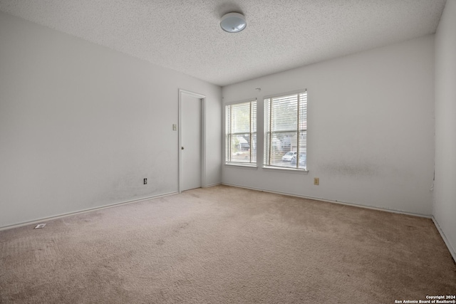 unfurnished room featuring carpet flooring and a textured ceiling