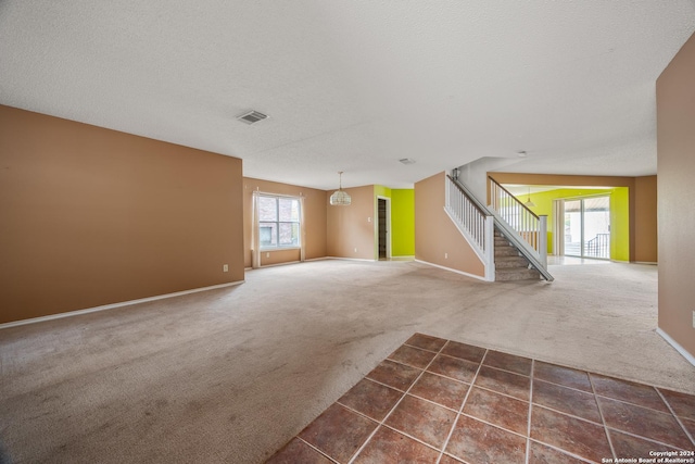 spare room featuring a textured ceiling and dark colored carpet