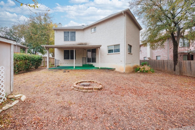 rear view of house with a patio and a fire pit