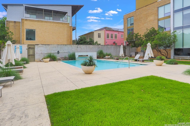 view of pool featuring a lawn and a patio area