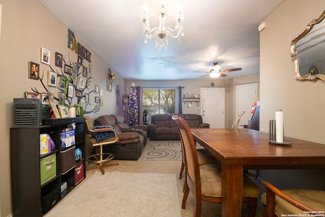 dining area featuring carpet and ceiling fan with notable chandelier