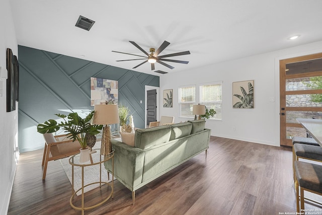 living room with ceiling fan and dark wood-type flooring