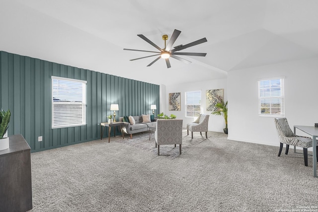 carpeted living room with ceiling fan, plenty of natural light, and vaulted ceiling