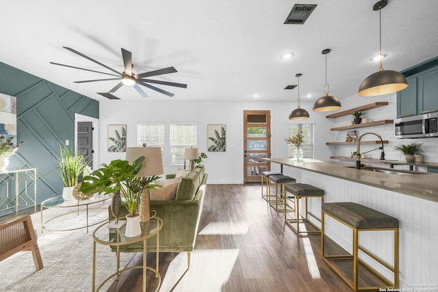 living room with ceiling fan, dark hardwood / wood-style flooring, and sink