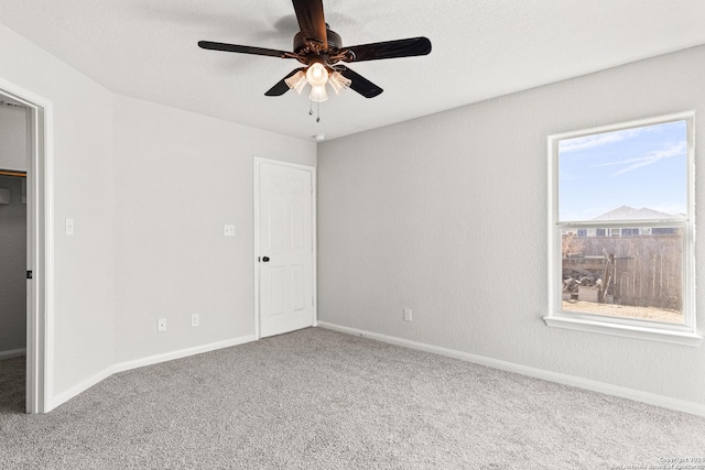 carpeted empty room featuring ceiling fan