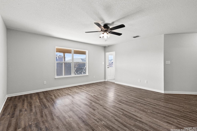 empty room with a textured ceiling, ceiling fan, and dark hardwood / wood-style floors