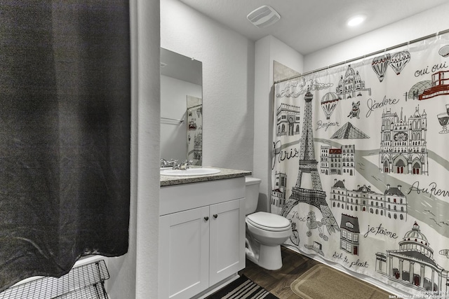 bathroom featuring walk in shower, vanity, wood-type flooring, and toilet