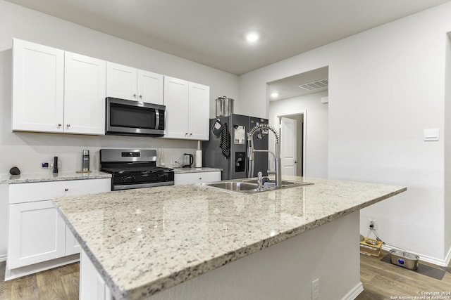 kitchen featuring white cabinetry, stainless steel appliances, and light wood-type flooring